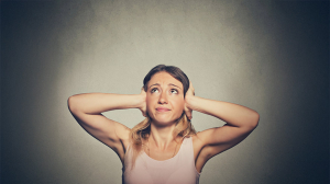 Overcoming the need to be understood - A young woman covering her ears.