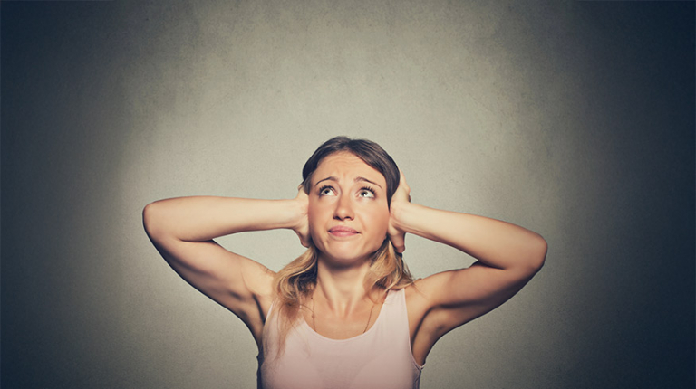 Overcoming the need to be understood - A young woman covering her ears.